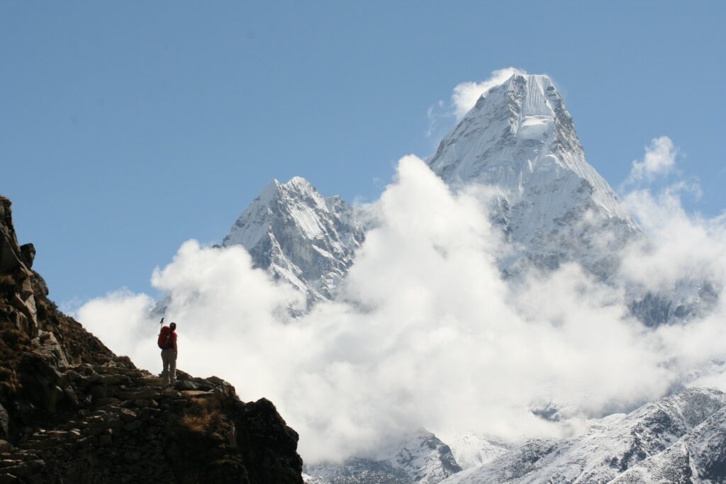 person standing on rock mountain during daytime